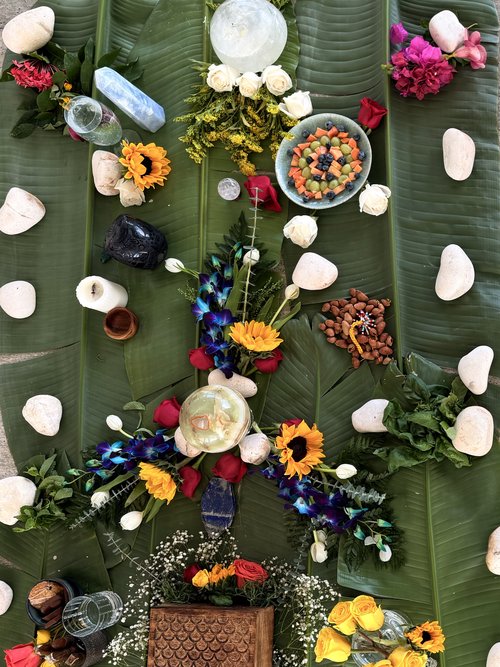 Altar overhead with banana leaves, stones, flowers, and crystals