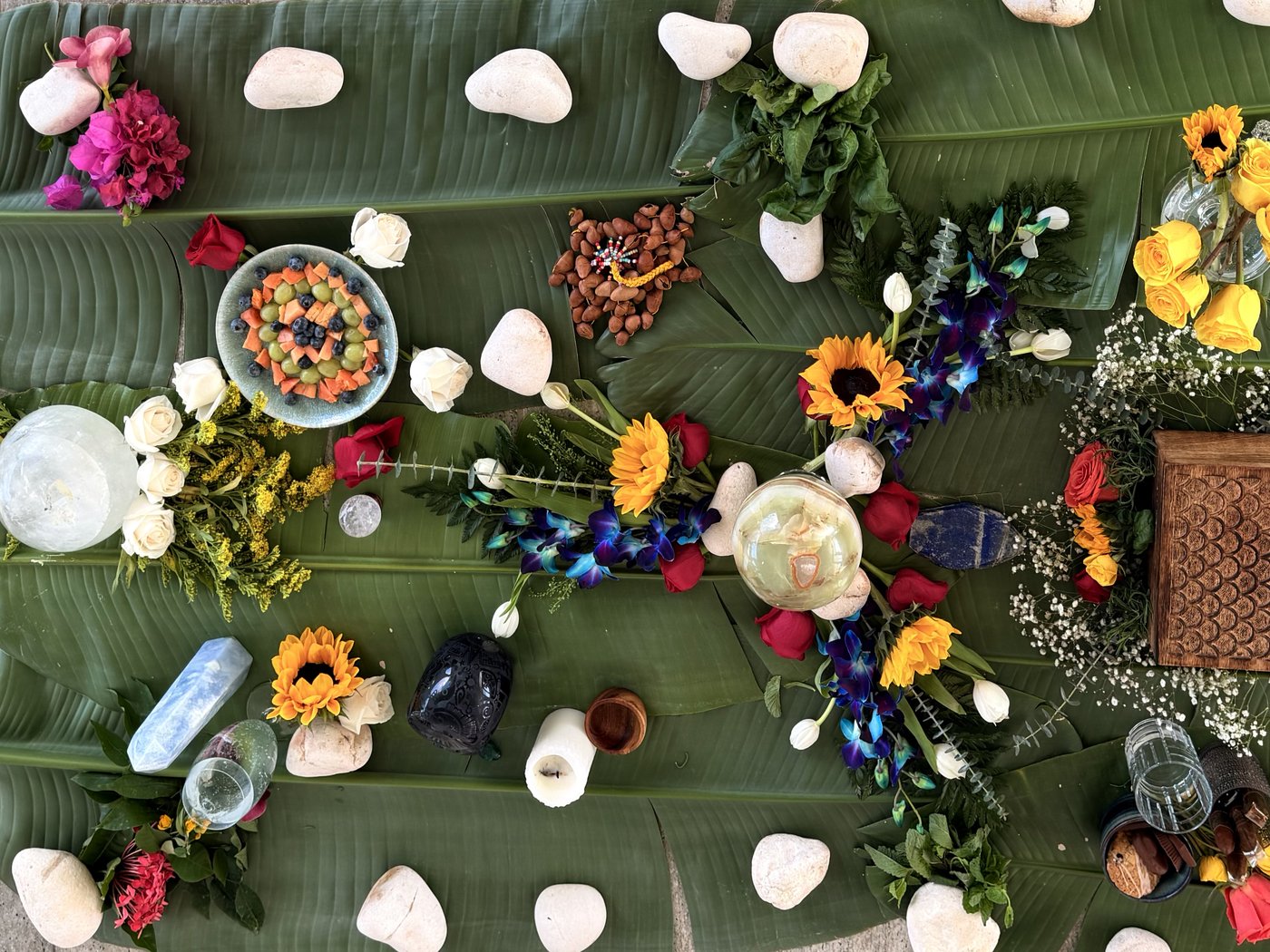 Altar at Casa Cielo: banana leaves with sunflowers, blue orchids, red roses, crystal sphere, almonds, white stones, ferns