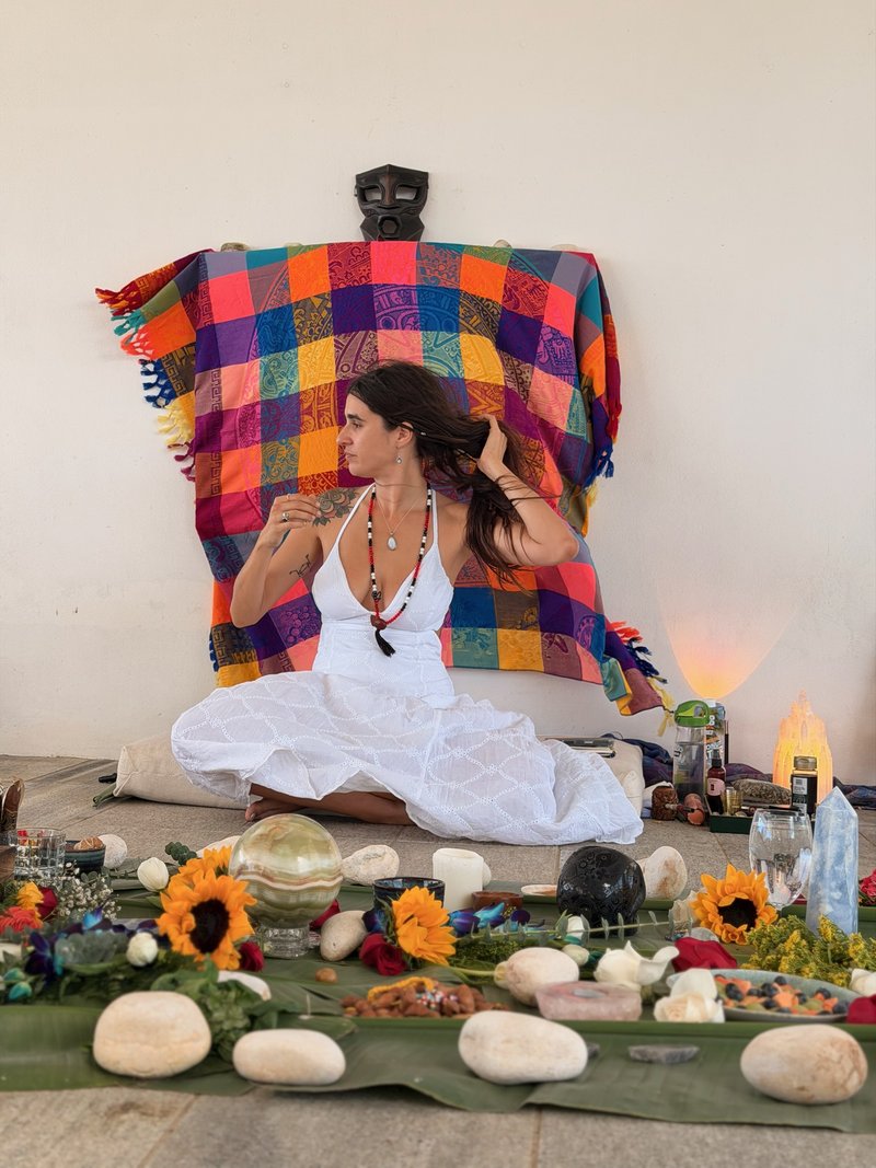 Johannie at her altar in Vieques, white dress, sunflowers and stones